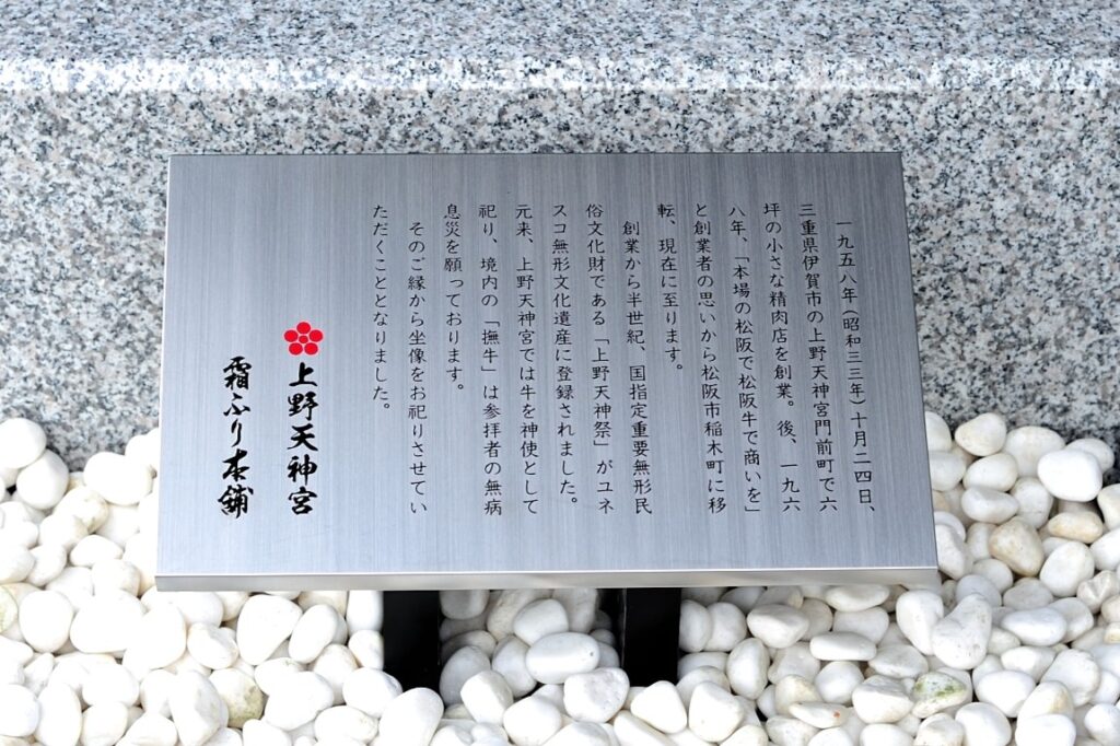 名産松阪牛 霜ふり本舗の入口前にある撫で牛の石像の説明石碑